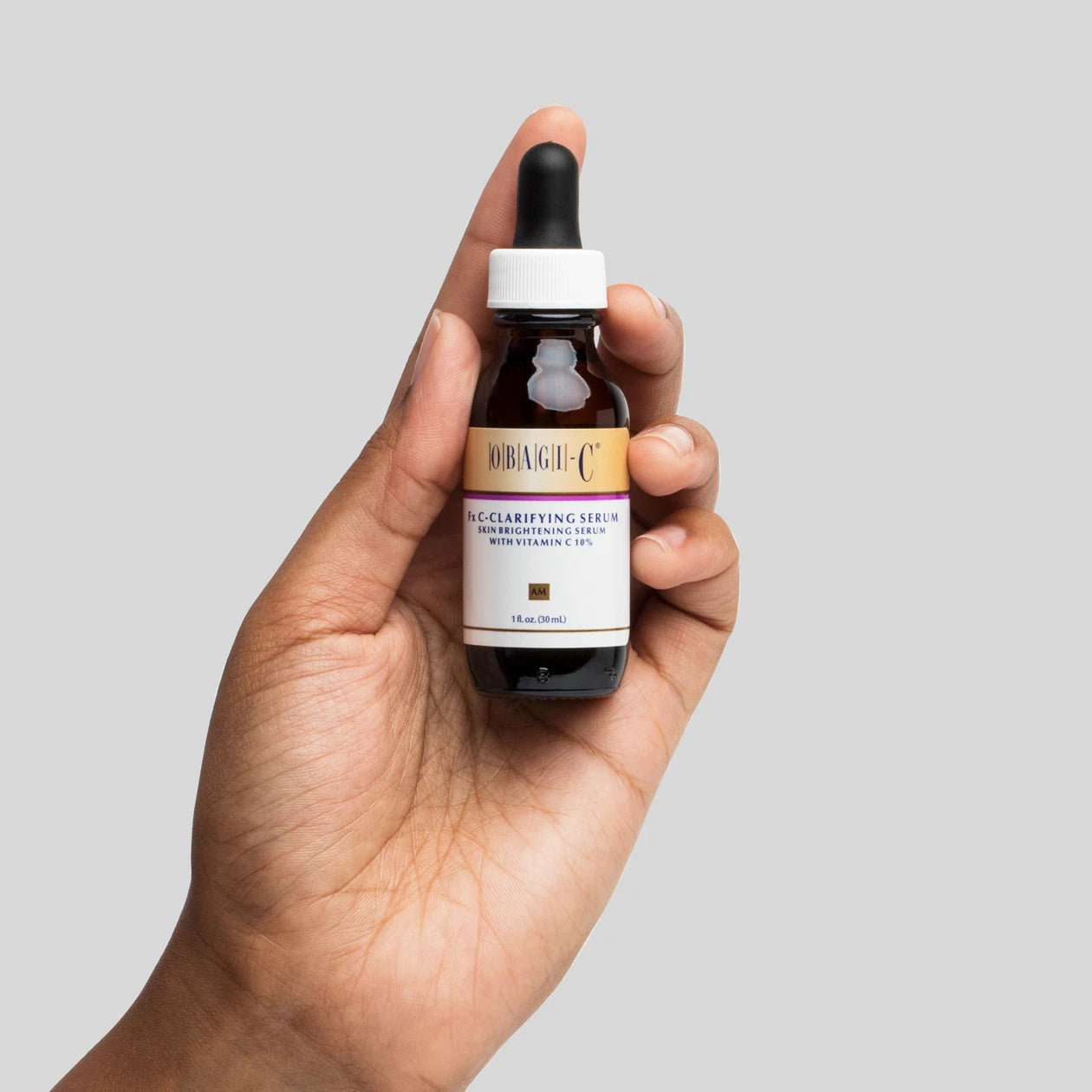 Obagi-C Fx C-Clarifying Serum bottle held in hand.
