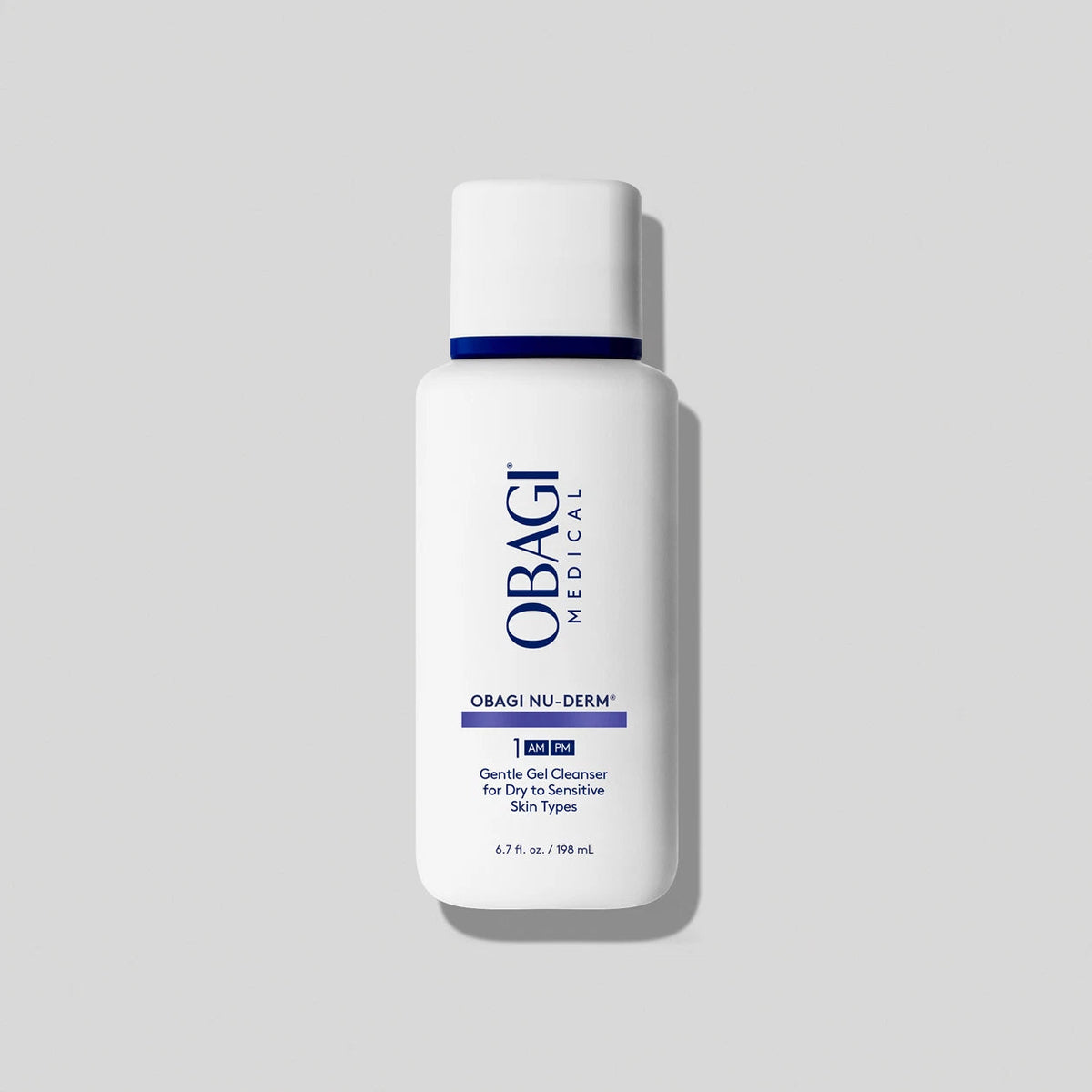 Obagi Nu-Derm Gentle Cleanser bottle with clear label, next to soft towels, emphasizing gentle skincare for sensitive skin.